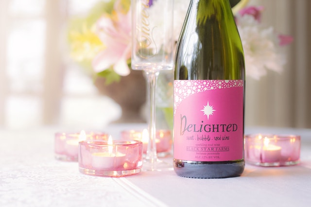 Fľaša s ružovou etiketou a nápisom „delighted“